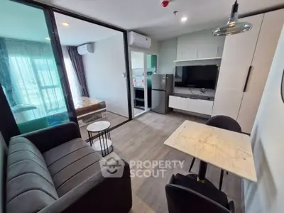 Modern open-plan living room with sleek furniture and kitchen in a stylish apartment.