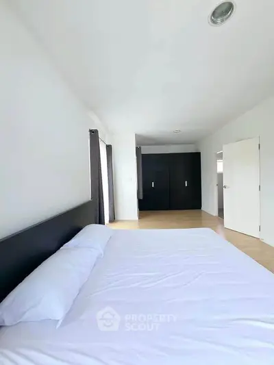 Spacious minimalist bedroom with modern design and ample natural light