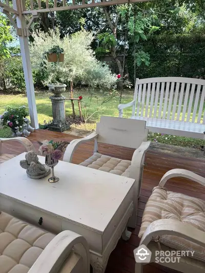 Charming garden patio with elegant white furniture and lush greenery