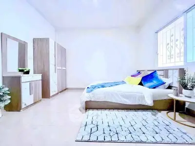 Spacious modern bedroom with stylish decor and ample natural light.