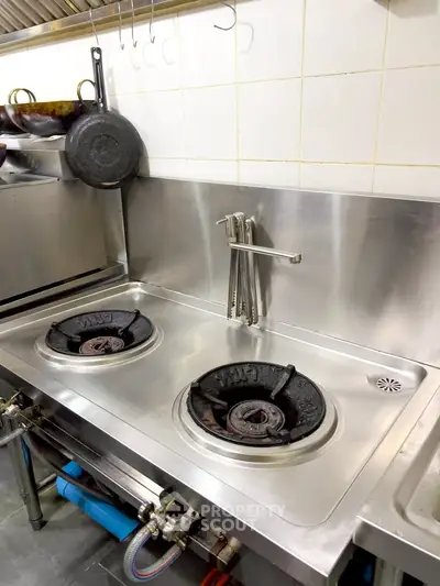 Modern stainless steel kitchen with dual gas stoves and sleek design