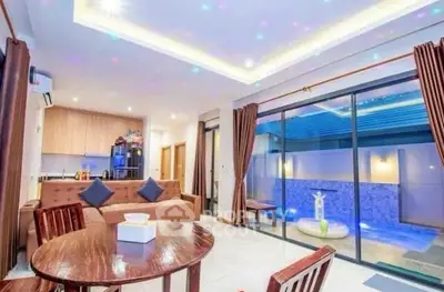 Modern open-plan living room with pool view and stylish lighting