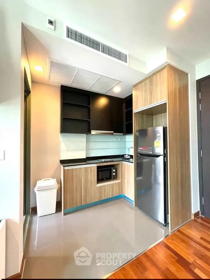 Modern kitchen with sleek cabinetry and stainless steel appliances in a stylish apartment.