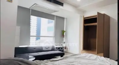 Modern bedroom with large window and open closet in urban apartment