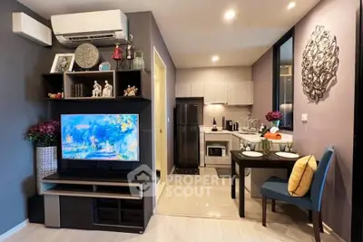 Modern living room with open kitchen, stylish decor, and cozy dining area in a compact apartment.