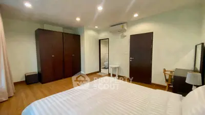 Spacious bedroom with modern furniture and wooden flooring