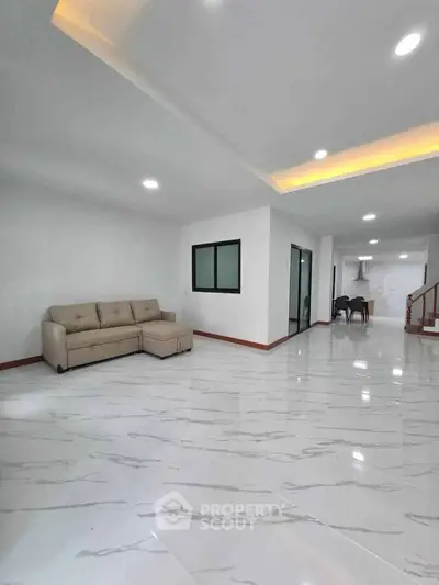 Spacious modern living room with sleek marble flooring and cozy seating area.