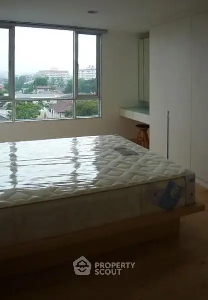 Spacious bedroom with large window offering scenic views and ample natural light.