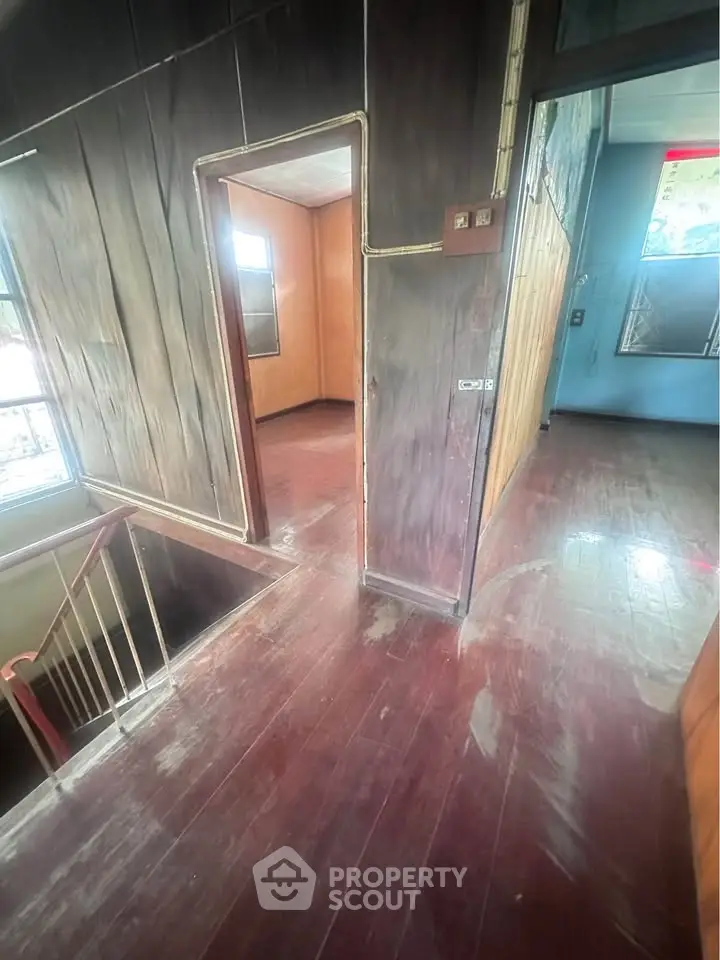Spacious wooden interior hallway with natural light and open doorways