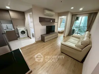 Modern apartment interior with open layout, featuring a cozy living room, kitchen, and balcony view.