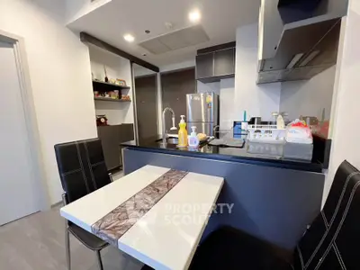 Modern kitchen with sleek black cabinets and dining area in stylish apartment