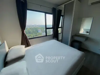 Modern bedroom with large window offering stunning city view and sleek furnishings.