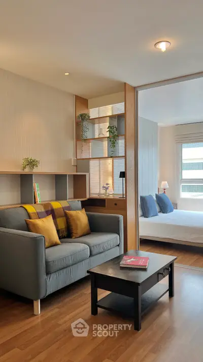 Modern living room with cozy sofa and stylish decor leading to a bright bedroom