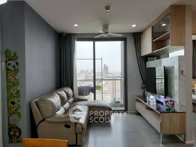 Modern living room with city view, stylish furniture, and large windows in a high-rise apartment.