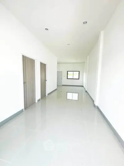 Spacious and bright interior hallway with modern design and sleek tile flooring.