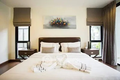 Luxurious bedroom with elegant decor and large windows offering natural light.
