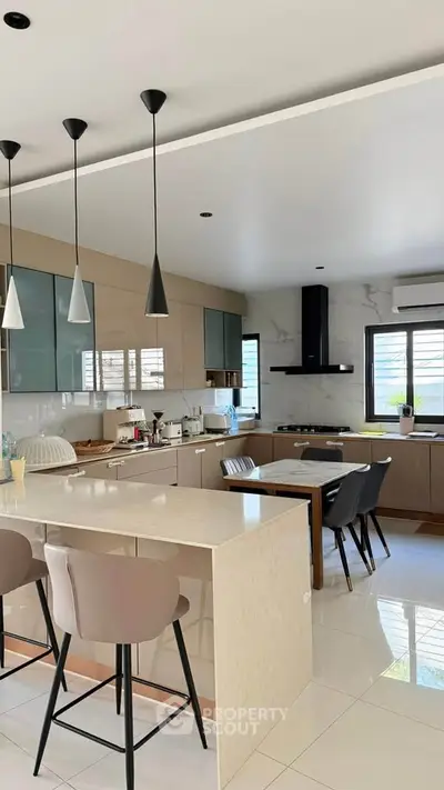 Modern kitchen with sleek design, featuring an open layout, stylish pendant lights, and a spacious island.