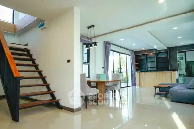 Spacious modern living room with elegant staircase and open dining area