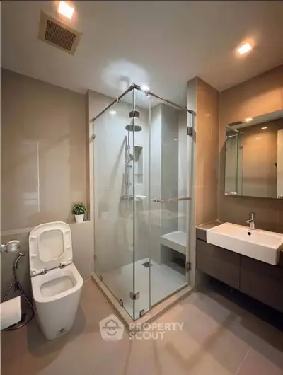 Modern bathroom with glass shower enclosure and sleek fixtures