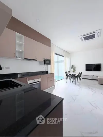 Modern open-layout kitchen and living room with sleek design and natural light.