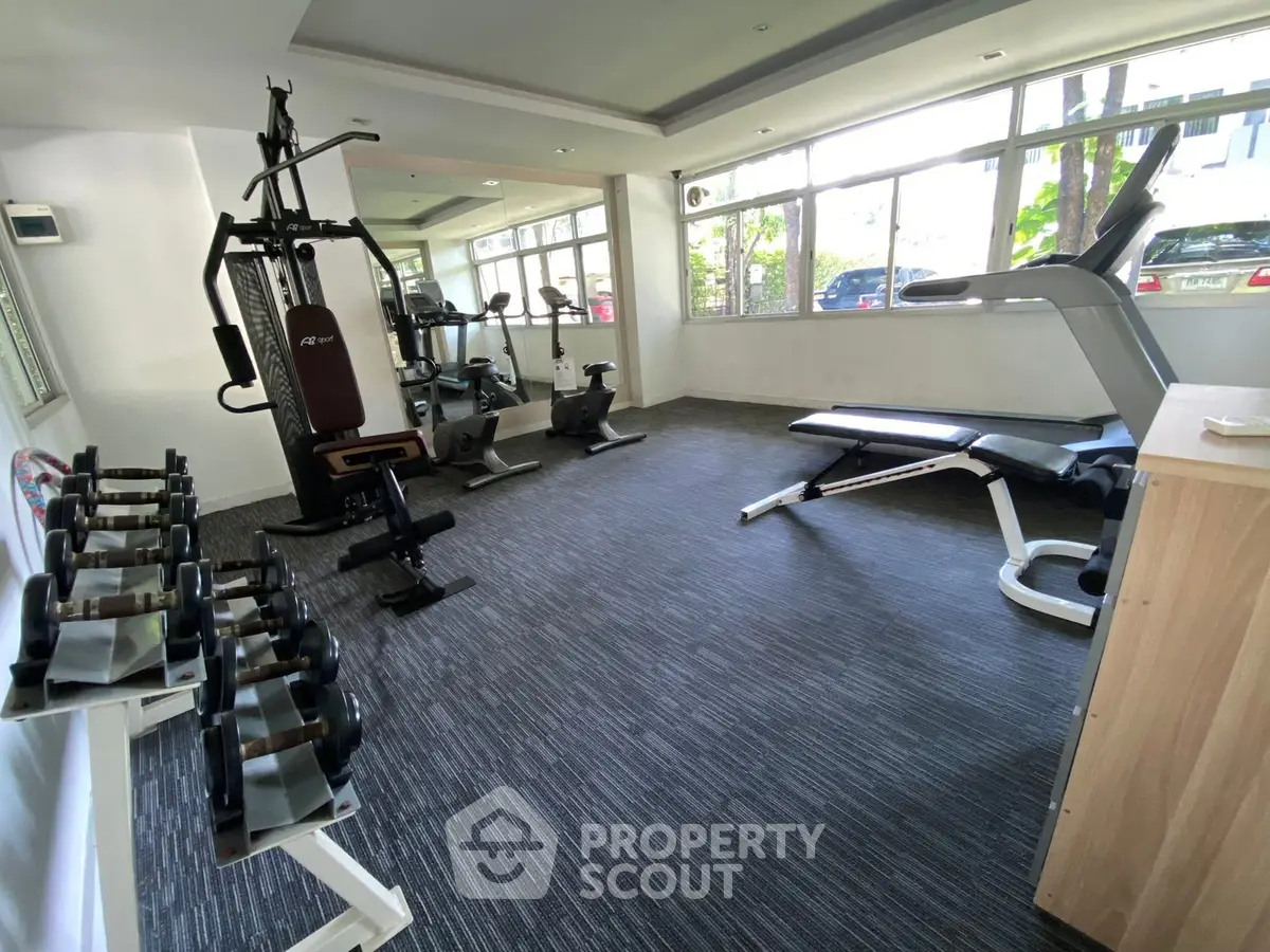 Modern gym with state-of-the-art equipment and large windows for natural light.