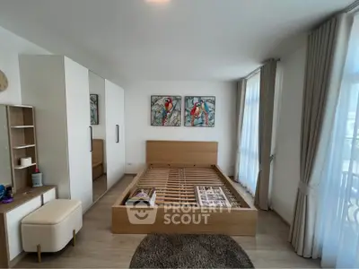 Spacious bedroom with modern wooden bed frame, large windows, and stylish decor.