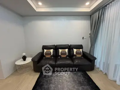 Modern living room with sleek black leather sofa and stylish decor