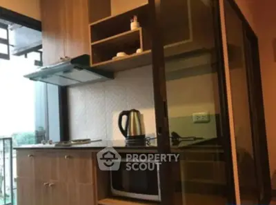 Compact kitchen with modern appliances and open layout in cozy apartment.