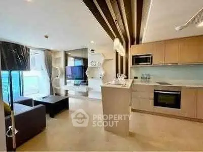 Modern open-layout living room with sleek kitchen and stylish decor, perfect for urban living.