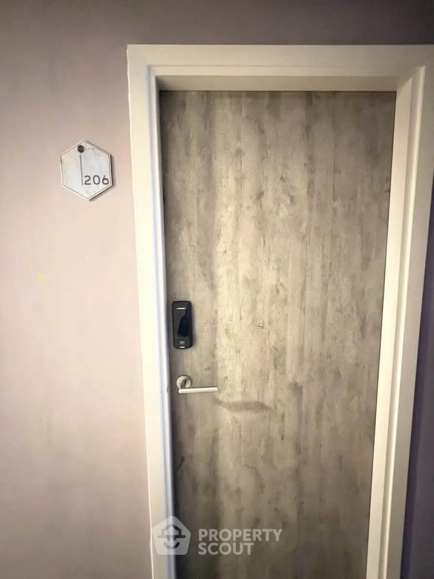 Modern apartment door with electronic lock and room number 206, showcasing secure entry.