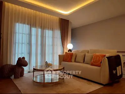 Elegant living room with cozy sofa, stylish lighting, and floor-to-ceiling curtains.