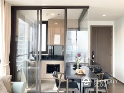 Modern apartment interior with open layout kitchen, sleek dining area, and abundant natural light from balcony doors.