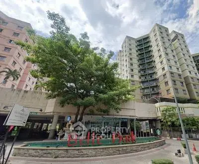 Modern high-rise residential building with lush greenery and welcoming entrance.
