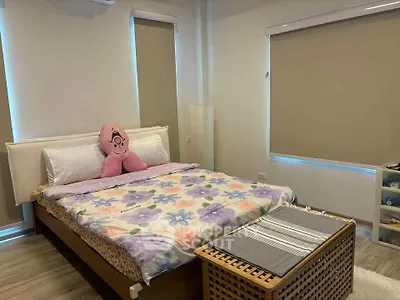 Cozy bedroom with floral bedding and modern decor, perfect for relaxation.