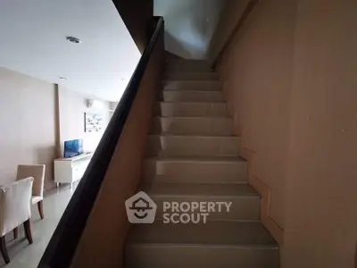 Modern interior staircase with sleek design and adjacent dining area.
