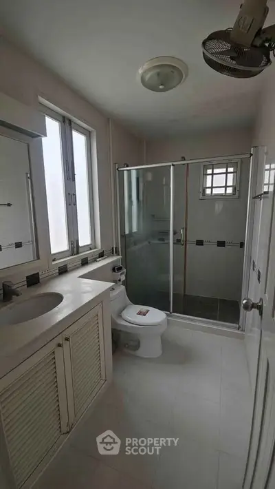 Modern bathroom with glass shower and sleek fixtures in a bright, airy space.
