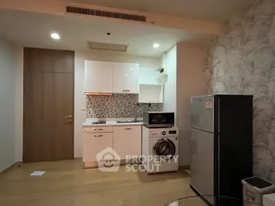 Modern kitchen with washing machine and fridge in compact apartment