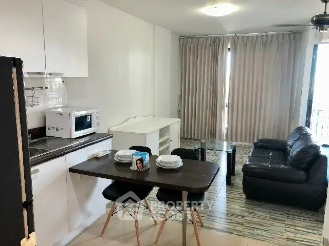 Modern open-layout kitchen and living room with sleek furniture and natural light.