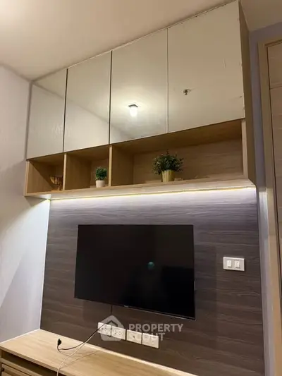 Modern living room with wall-mounted TV and stylish shelving