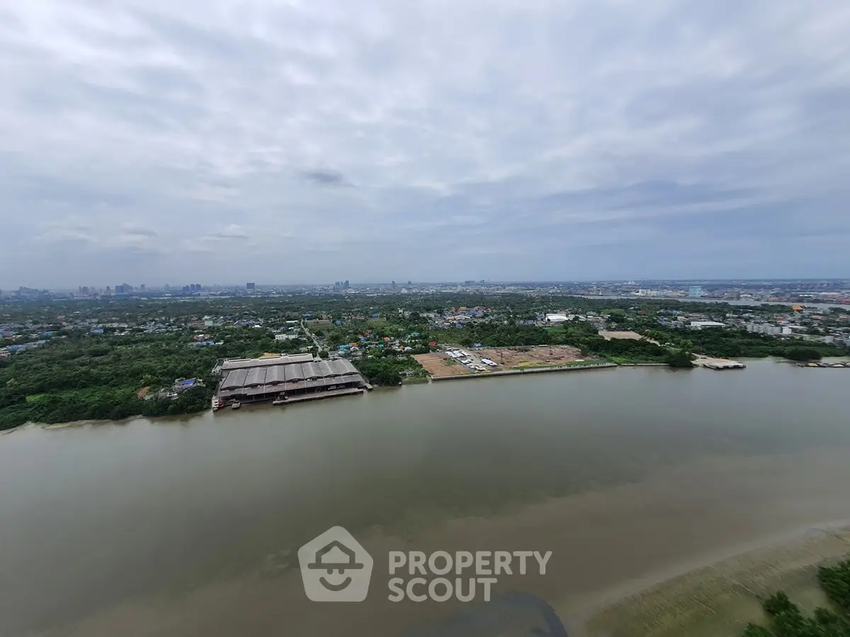 Stunning panoramic river view with lush greenery and distant city skyline, perfect for serene living.