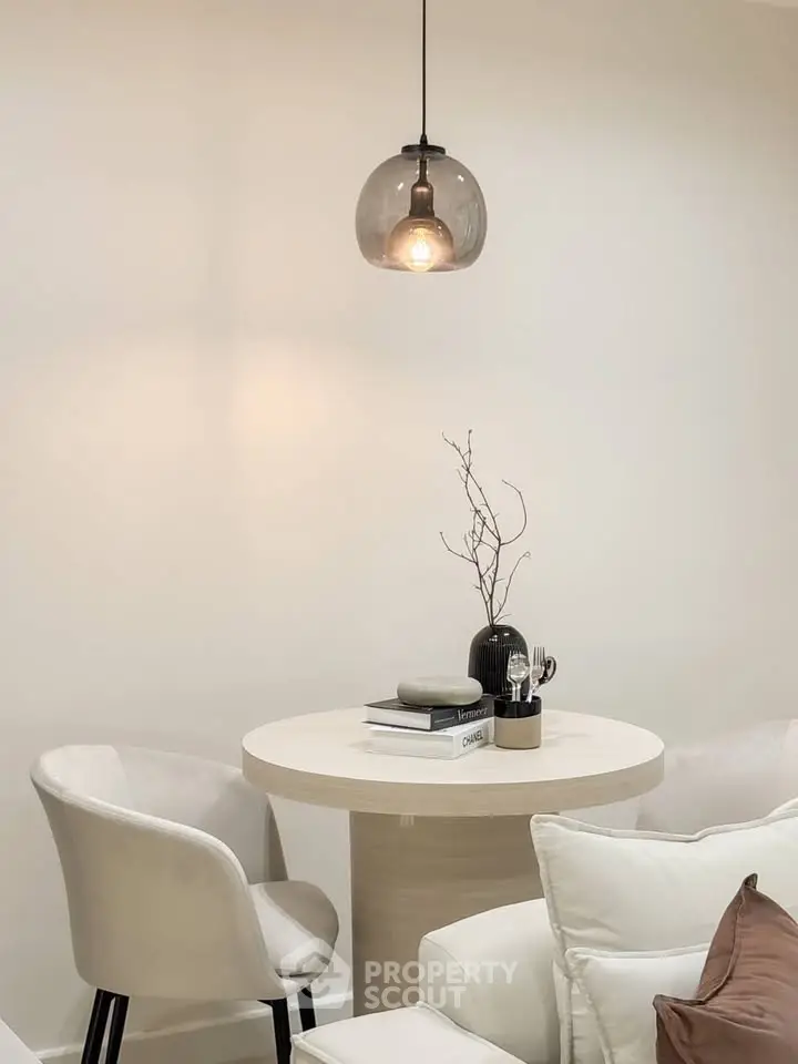 Elegant modern living room with chic round table and stylish pendant light.