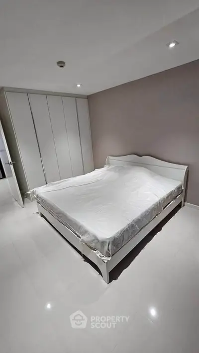 Spacious bedroom with modern white furniture and ample closet space