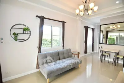 Modern living room with elegant chandelier and cozy gray sofa