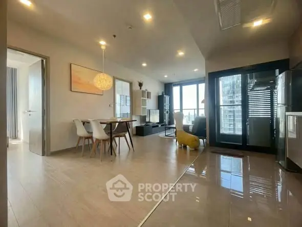 Spacious modern living room with open layout and city view, featuring elegant dining area and stylish decor.