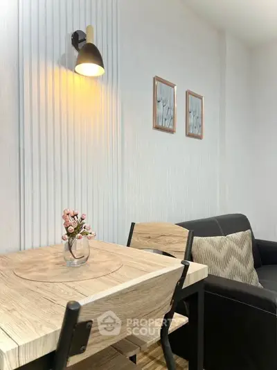 Cozy living room with modern decor, featuring a wooden table, stylish chairs, and a comfortable sofa.