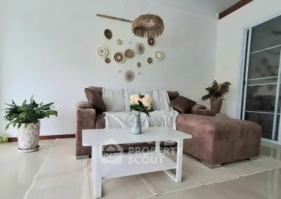 Stylish living room with cozy brown sofa, white coffee table, and chic wall decor, perfect for modern living.