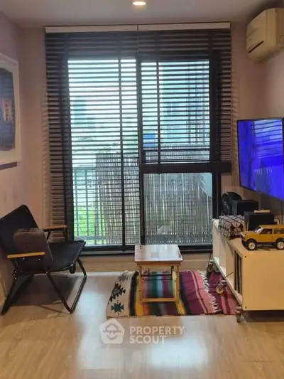 Cozy living room with modern decor and large window with blinds