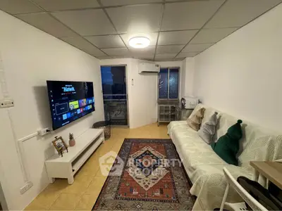 Cozy living room with modern decor, wall-mounted TV, and balcony access in a stylish apartment.