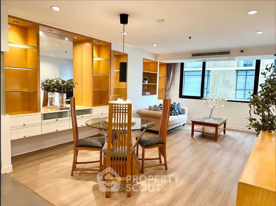 Spacious living room with elegant dining area and modern decor in a well-lit apartment.