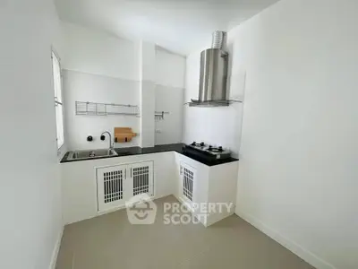 Modern minimalist kitchen with gas stove and sleek white cabinets